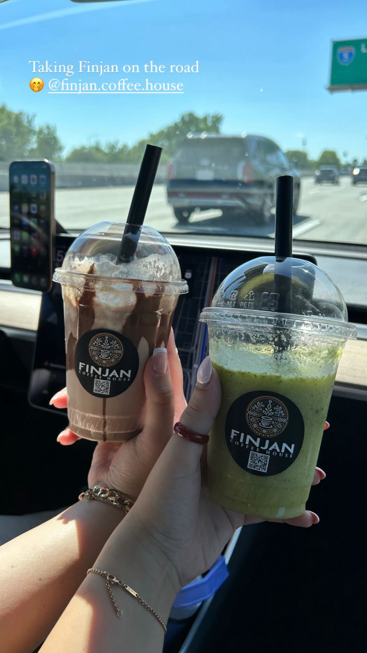 Two Finjan iced drinks held up on the road
